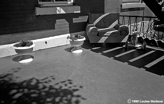 Fauteuil, tricycle et pots de fleurs