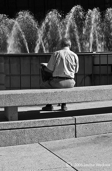 Man Reading Sitting Around a Building